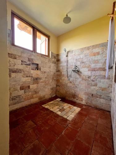 a bathroom with a shower with a brick wall at Tabingi Safari Lodge in Katunguru