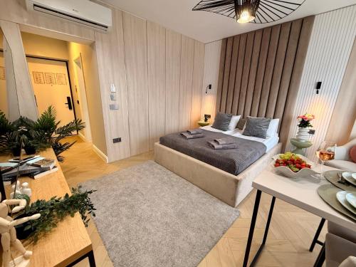 a bedroom with a bed and a table in a room at AIASTAY Bucharest River Apartments in Bucharest