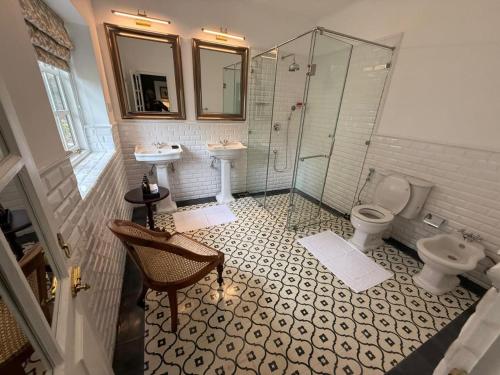 ein Badezimmer mit zwei Waschbecken, einer Dusche und einem WC in der Unterkunft Powysland Bungalow in Nuwara Eliya