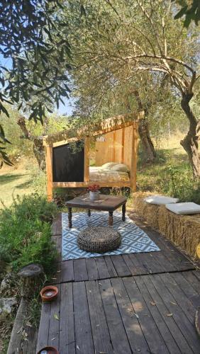 a wooden deck with a bench and a table at The SkyRoom - AUT vita sotto gli alberi in Calcata