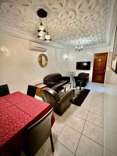 a living room with a red table and chairs at Hôtel du Boulevard in Brazzaville