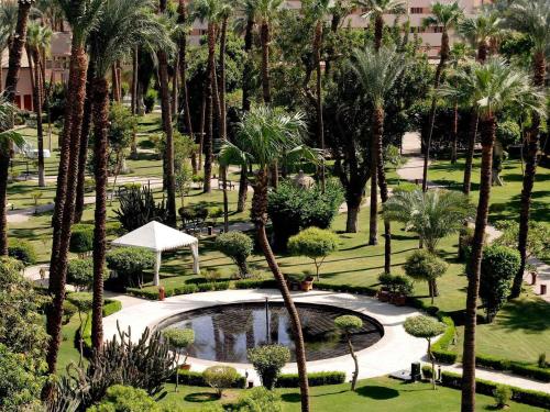an aerial view of a park with palm trees and a pool at Pavillon Winter Luxor in Luxor