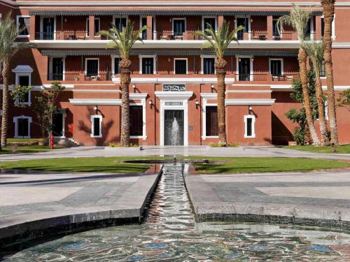 a building with a fountain in front of a building at Sofitel Legend Old Cataract in Aswan