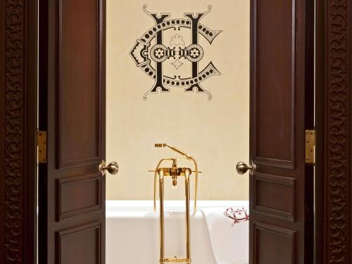 a bathroom with a bath tub with a gold faucet at Sofitel Legend Old Cataract in Aswan