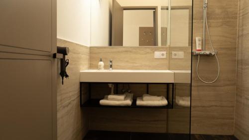 a bathroom with a sink and a shower with towels at Elias Residence Vienna in Vienna