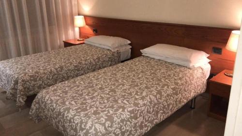 Una habitación de hotel con dos camas y dos lámparas. en Hotel Select, en Sant'Ilario d'Enza