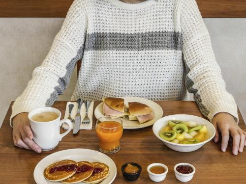 a person sitting at a table with a plate of food at Hotel Ibis Coimbra Centro in Coimbra