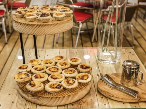 a display of cupcakes on a wooden table at Hotel Ibis Coimbra Centro in Coimbra
