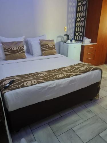 a large bed in a room with at Zurich garden lodge benoni in Benoni