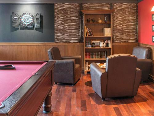 a billiard room with a pool table and chairs at ibis Falaise Coeur de Normandie in Falaise