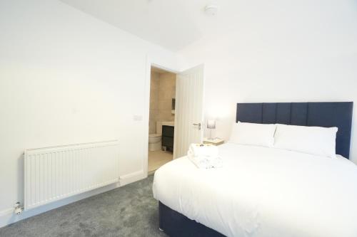 a bedroom with a large bed with white sheets at The Lodge in Dunmore