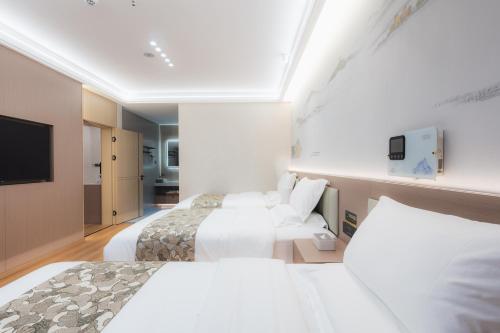 a hotel room with two beds and a flat screen tv at Shangge Boya Hotel in Shangri-La