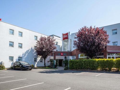 a hotel with a car parked in a parking lot at ibis Massy in Massy