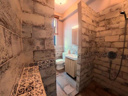 a bathroom with a shower and a toilet and a sink at The Red House in Hong Kong