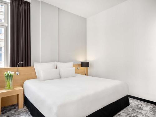 a bedroom with a large white bed and a window at Nemzeti Hotel Budapest - MGallery Collection in Budapest