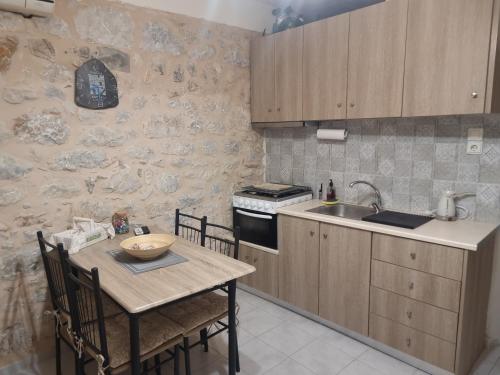 a small kitchen with a table and a sink at Λαγκάδι Μάνης in Koíta