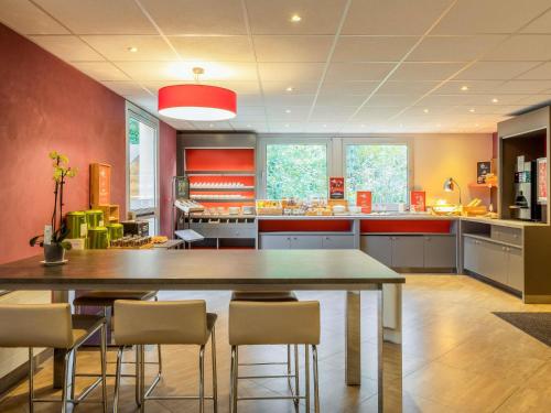a large kitchen with a large table and chairs at ibis Velizy Jouy-En-Josas in Jouy-en-Josas