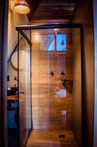 a shower with a glass door in a room at Chalé Águia in Petrópolis