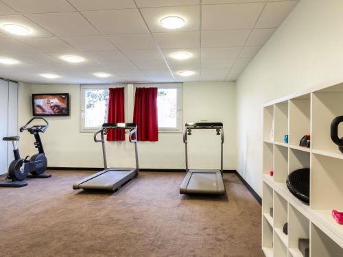 a gym with two treadmills and two exercise bikes at ibis Velizy Jouy-En-Josas in Jouy-en-Josas