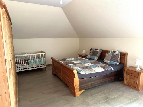 a bedroom with a bed and a crib in it at Ferienwohnung Jasi, OG 95174 in Rhauderfehn