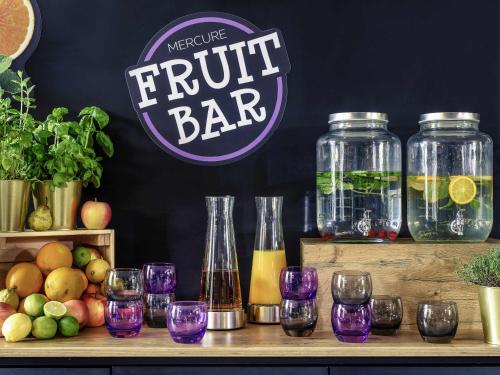 a table with wine glasses and a fruit bar at Mercure München am Olympiapark in Munich