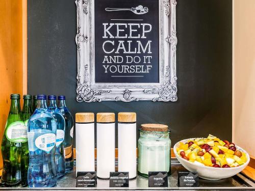 a table with bottles and a sign that says keep calm and dont yourself at Hotel ibis Evora in Évora