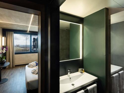 a bathroom with a sink and a mirror at Novotel Genova City in Genova