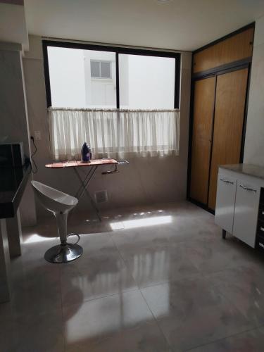 a room with a table and a chair in front of a window at Amplio excelente ubicación Calacoto in Irpavi