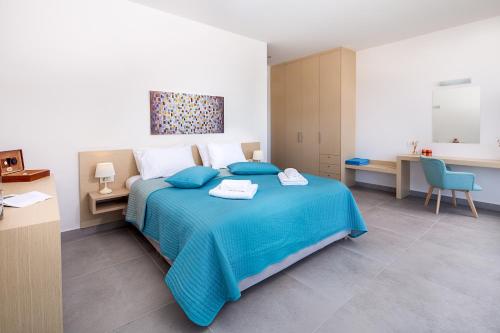 um quarto com uma cama azul e um cobertor azul em Sea Queen Villa em Kato Daratso