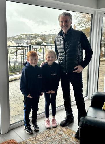 a man and two boys standing in front of a window at BayView Luxury 4 Bedroom Penthouse in Downings