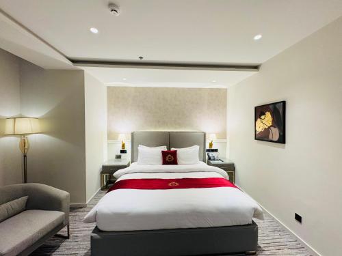 a bedroom with a large bed and a couch at Taj Executive Hotel Islamabad - Luxury Stays Opposite Jinnah Super F-7 in Islamabad