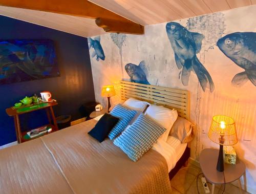 a bedroom with a bed with a painting on the wall at Le Grand Bain in Marciac