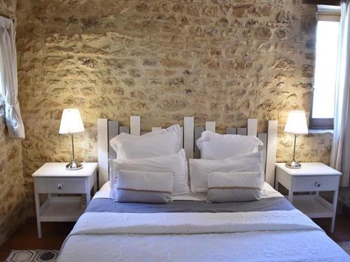a bed with white pillows and two tables with lamps at Charmante maison périgourdine avec piscine et parking à Calés - FR-1-824-20 in Calès