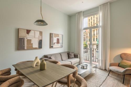 a living room with a table and chairs at Aspasios Rambla Catalunya Apartments in Barcelona