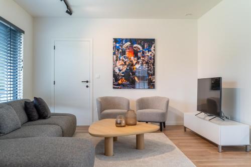 a living room with a couch and a tv at Villa Weidezicht in Heusden - Zolder