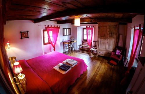 ein Schlafzimmer mit einem rosa Bett und einem Tisch in der Unterkunft Bed & Breakfast Uvablu in Trontano