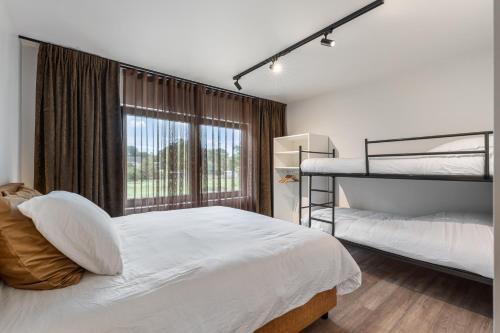a bedroom with two bunk beds and a window at Villa Weidezicht in Heusden - Zolder