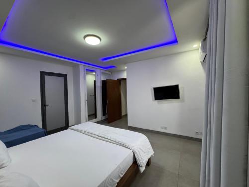 a bedroom with a white bed with a blue ceiling at Moderne 2 bed Penthouse in Dakar