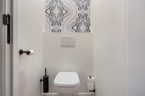 a bathroom with a toilet and a picture on the wall at Villa Weidezicht in Heusden - Zolder