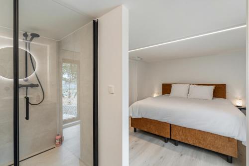 a bedroom with a bed and a walk in shower at Villa Weidezicht in Heusden - Zolder