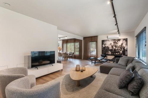 a living room with two couches and a tv at Villa Weidezicht in Heusden - Zolder