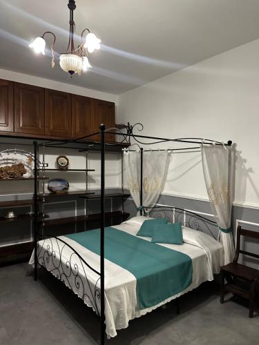 a bedroom with a black canopy bed with a blue blanket at Casa Vacanza L'Aurora in Vico Equense