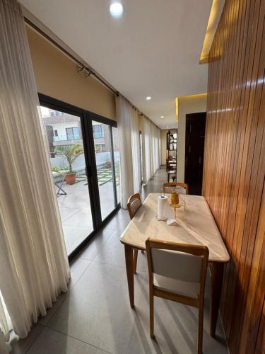 a table and chairs in a room with a large window at Moderne 2 bed Penthouse in Dakar