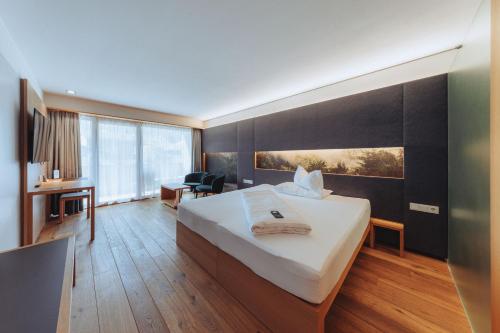 a hotel room with a bed and a desk at Sonne Mellau - Feel good Hotel in Mellau