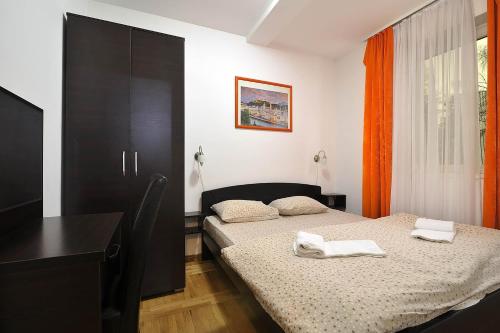 a bedroom with a bed with two towels on it at Vila Mina in Zlatibor