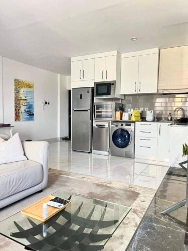 a living room with a couch and a kitchen at Luxury 1 bdrm Suite, Cantonments-Labone in Accra