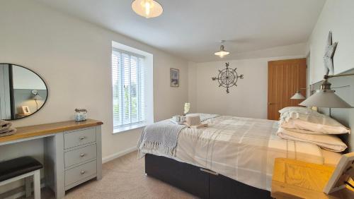 a bedroom with a large bed and a mirror at Seabreeze Cottage 2 bedroom - Sleeps 6 - Bron-Y-Wendon Holiday Park in Llanddulas