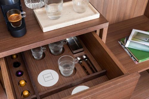 a wooden drawer with glasses on a table at NAMAN HOTELLERIE - Condotti in Rome