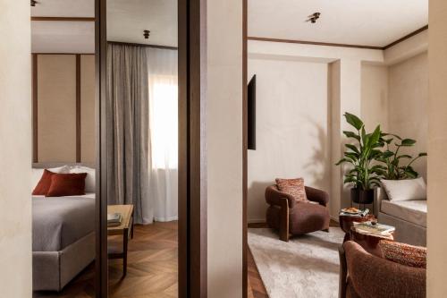 a living room with a mirror and a chair at NAMAN HOTELLERIE - Condotti in Rome
