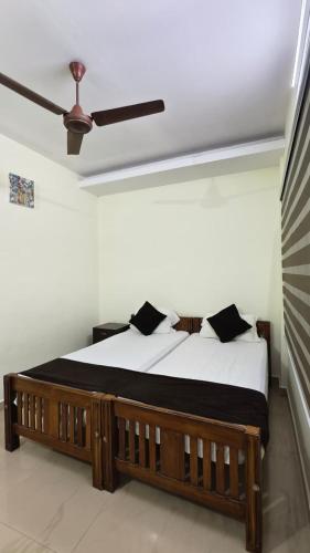 a bedroom with a wooden bed with black pillows at UPPERCREST RESIDENCY PALA in Pala